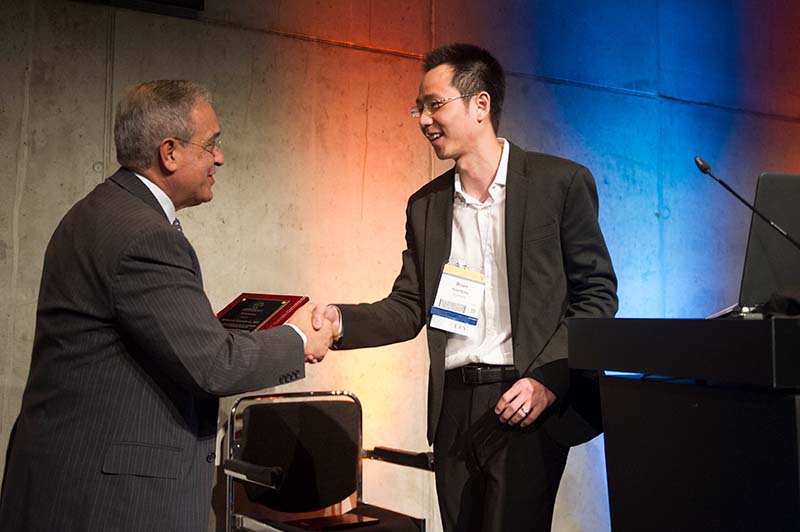 A junior awardee accepts a plaque after presenting an abstract to the International Congress.  